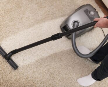Close up of vacuuming a carpet How Upholstery Cleaning